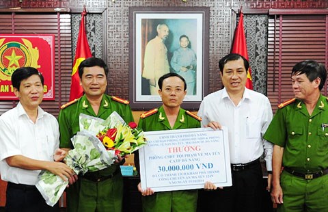 Ông Huỳnh Đức Thơ - Phó Chủ tịch UBND TP Đà Nẵng (người đứng thứ hai, bên phải) trao bằng khen, tiền thưởng cho ban chuyên án. 