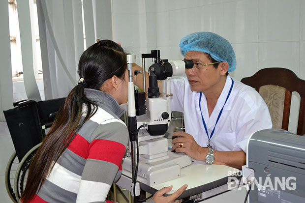 Bệnh đau mắt đỏ có xu hướng tăng trong mùa mưa lũ. TRONG ẢNH: Bác sĩ Nguyễn Văn Khôi tại phòng khám, Bệnh viện Mắt. (Ảnh chụp chiều 18-11)
