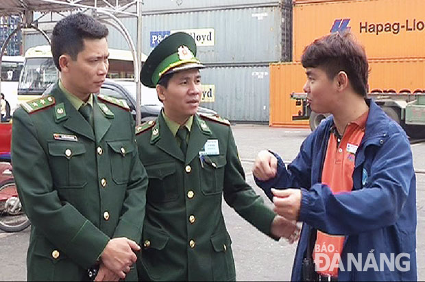 Trung tá Nguyễn Thành Đính (trái) kiểm tra công tác xuất nhập cảnh tại cảng Tiên Sa.