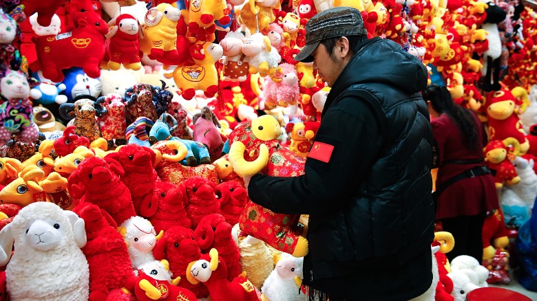 Ảnh chụp một người chủ sạp tại Bắc Kinh đang bài trí cửa hàng thú bông của mình ngày 13-2-2015. Theo Âm lịch, Năm Mùi hoặc Cừu tùy theo cách hiểu của mỗi người, sẽ bắt đầu từ ngày 19-2 tới.