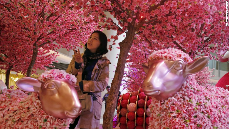 Hôm 6-2, tại Hong Kong, một cô gái đứng chụp ảnh tại một khu trưng bày mừng năm mới, Năm con dê theo lịch âm 2015.