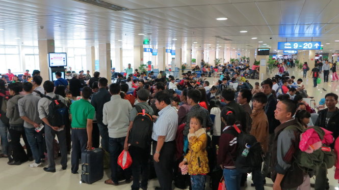 Hành khách rồng rắn xếp hàng ở sân bay Tân Sơn Nhất, chuẩn bị lên máy bay trong ngày cao điểm - Ảnh: Lê Nam