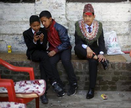Chú rể Khil Bahadur Ghale, 25 tuổi đang ngồi đợi cô dâu Bishma Punj kém mình một tuổi để làm lễ cưới tại đền thờ ở Kathmandu.