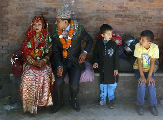Một đôi uyên ương khác là Kamal Thapa, 28 tuổi và cô dâu Shobha Thapa, 25 tuổi ngồi chờ khách tới chia vui sau khi làm lễ trong ngôi đền.