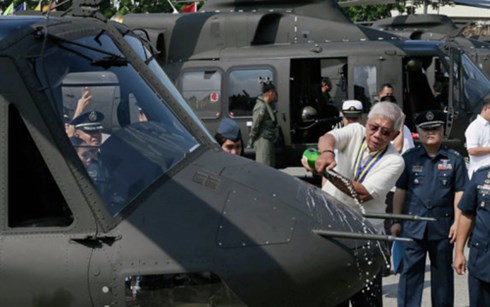 Bộ trưởng Quốc phòng Philippines làm lễ đổ rượu Champagne lên một chiếc trực thăng trong lễ tiếp nhận 10 chiếc Bell-412EP. (Ảnh: AP)