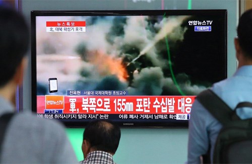 Người dân Hàn Quốc xem truyền hình cảnh pháo binh 155 mm của Hàn Quốc bắn trả đũa vụ Triều Tiên nã pháo sang lãnh thổ Hàn Quốc, chiều 20.8.2015 - Ảnh: AFP