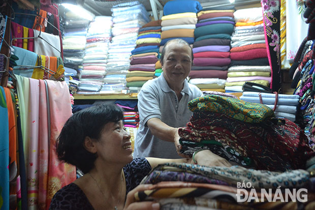 Suốt 31 năm nay, ông Nguyễn Ngọc Ân đều đặn mỗi sáng, mỗi chiều ra chợ để phụ vợ dọn hàng tại sạp vải Ân Trình, chợ Hàn. Ảnh: M.T