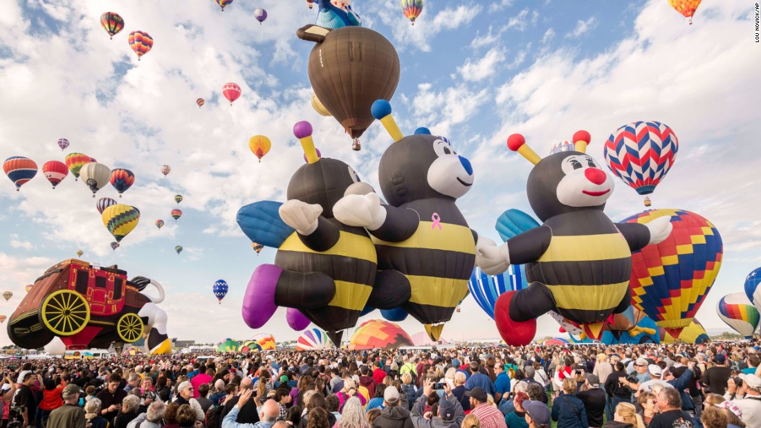 Một đàn ong là những khí cầu, bên cạnh là một khí cầu khác hình chiếc xe, hình con bò.