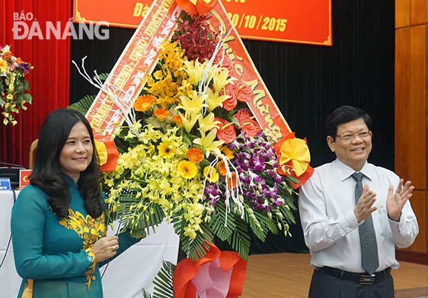 Phó Bí thư thường trực Thành ủy Võ Công Trí tặng hoa chúc mừng Ngày Phụ nữ Việt Nam. Ảnh: BÌNH AN