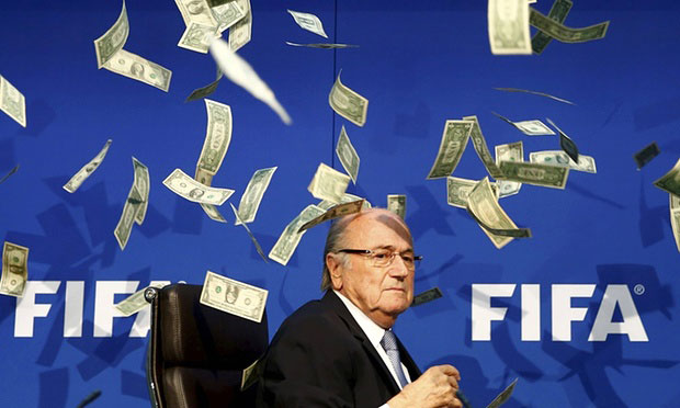 20 tháng 7: Chủ tịch FIFA lộ vẻ khó chịu khi diễn viên hài Simon tung những tờ đô-la giả bay tung tóe trước mặt. (Nguồn: Guardian)