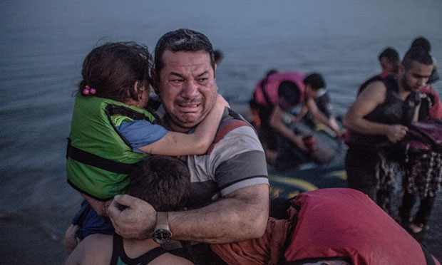 Laith Majid chồng của Neda Al-Amirij, ôm con gái và con trai, vỡ òa niềm vui khi đến bờ đảo Kos của Hy Lạp. (Nguồn: Guardian)