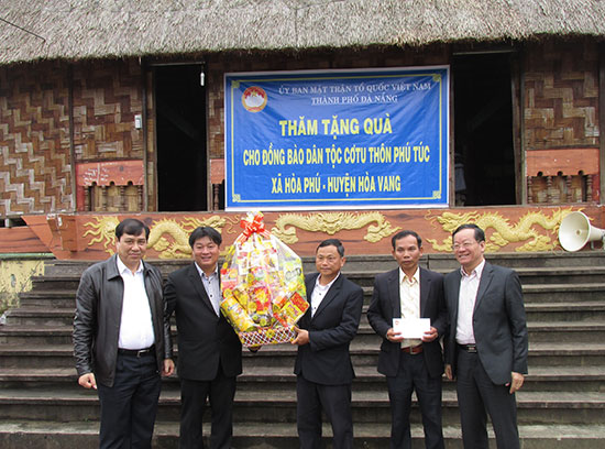 Chủ tịch UBND xã Hòa Phú Nguyễn Ngọc Hải (thứ hai, trái sang) nhận quà của thành phố tặng cho đồng bào Cơtu thôn Phú Túc. (Ảnh do nhân vật cung cấp) 