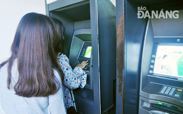 Các ngân hàng cho biết sẽ chuẩn bị đủ tiền mặt cung ứng Tết.  Trong ảnh: Khách hàng đang rút tiền mặt tại ATM.