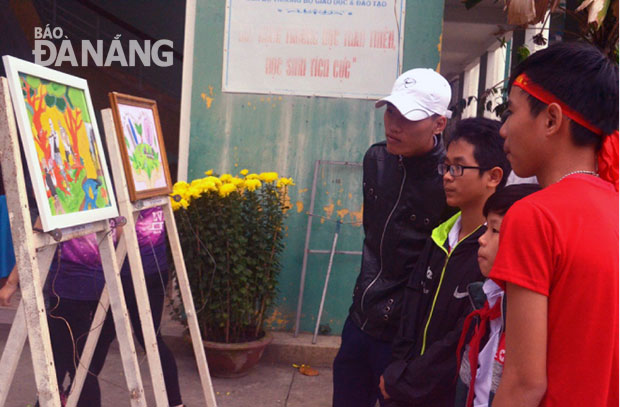 Tăng cường giáo dục bảo vệ môi trường bền vững từ trong nhà trường. TRONG ẢNH: Học sinh xem triển lãm tranh bảo vệ môi trường tại Trường THPT Nguyễn Hiền.