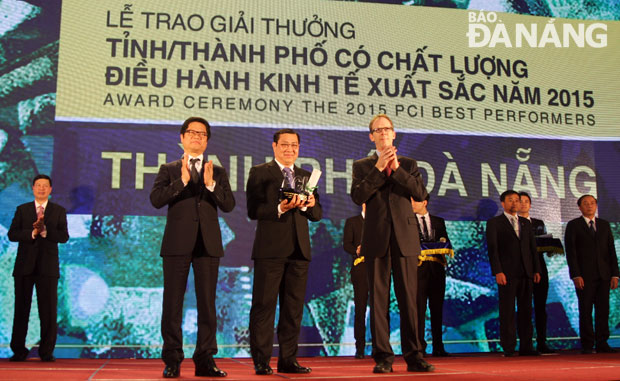 Chủ tịch UBND thành phố Huỳnh Đức Thơ nhận giải do Chủ tịch VCCI Việt Nam Vũ Tiến Lộc (ngoài cùng bên trái) và ông Joakim Paker, Giám đốc USAID Việt Nam trao