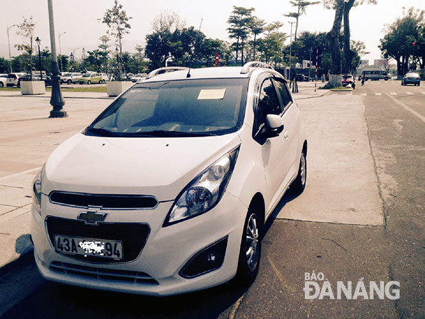 Thanh tra giao thông thành phố dán thông báo nộp phạt một ô-tô vi phạm lỗi đỗ xe không đúng nơi quy định trên đường Quang Trung.