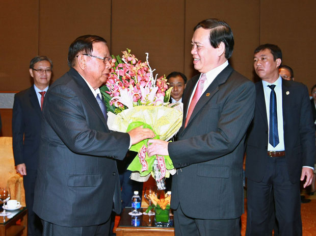 Chủ tịch Hội Hữu nghị Việt Nam - Lào Vũ Trọng Kim tặng hoa Tổng Bí thư, Chủ tịch nước Lào Bounnhang Volachith.Ảnh: TTXVN