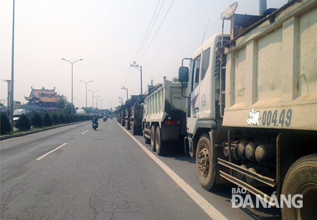 Khi có lực lượng Cảnh sát giao thông tuần tra, hàng chục xe ben chở đất lập tức “nằm đường” thành dãy dài trên quốc lộ 1A. (Ảnh chụp ngày 26-4).