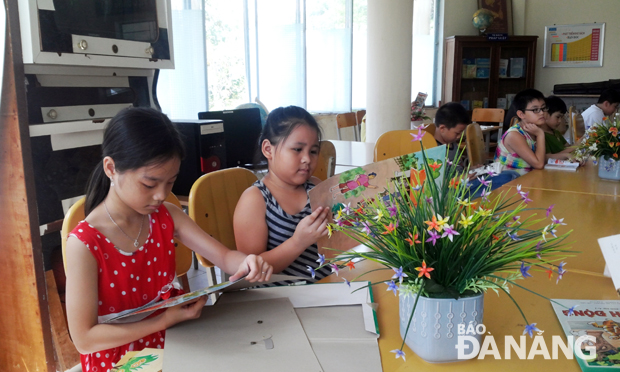 Học sinh Trường tiểu học Núi Thành đọc sách trong ngày hè tại thư viện của nhà trường.        							  			 Ảnh: PHƯƠNG TRÀ