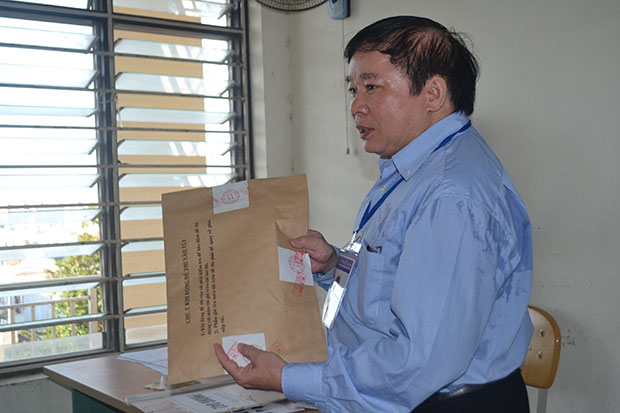 Thứ trưởng Bùi Văn Ga xem kỹ niêm phong đề thi trước khi thí sinh bước vào thi môn Sử, buổi sáng ngày 4-7