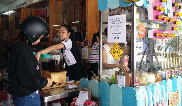 Cửa hàng thức uống của nhạc sĩ Nguyễn Duy Khoái dán thông báo không nhận Nhân dân tệ của du khách.  Ảnh: THU HÀ