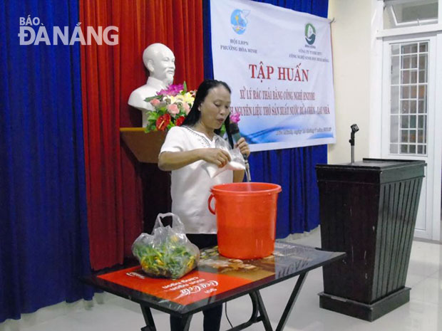 Chị Trịnh Thị Hồng hướng dẫn phụ nữ phường Hòa Minh (quận Liên Chiểu) cách làm nước tẩy rửa từ “rác thải” trong một buổi họp mặt của Hội Phụ nữ phường.		Ảnh: KHANG NINH 