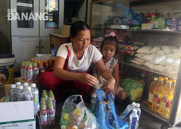 Chị Nguyễn Thị Thu Hiền chuẩn bị mang nước uống cho công nhân sau bữa trưa. Ảnh: L.G.L