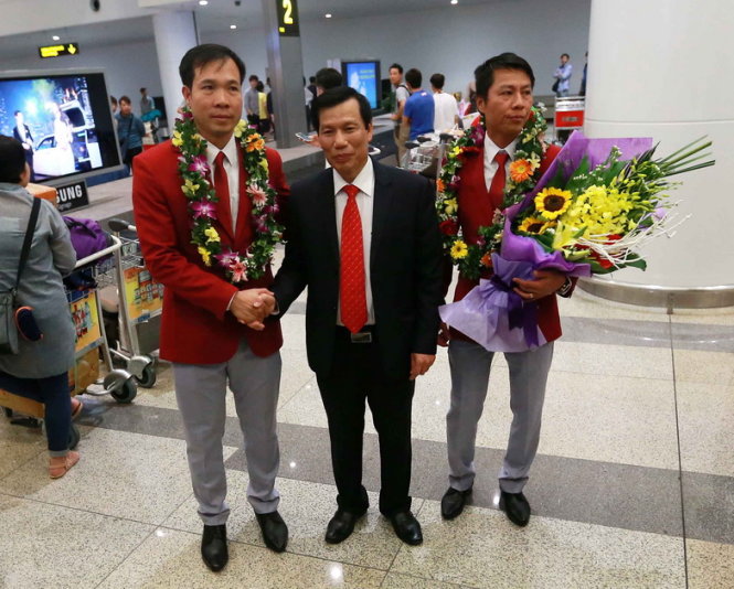 Hoàng Xuân Vinh (bìa trái) và xạ thủ Trần Quốc Cường (bìa phải) chụp ảnh lưu niệm với Bộ trưởng Bộ VH-TT&DL Nguyễn Ngọc Thiện.