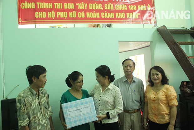 Đại diện Hội Liên hiệp Phụ nữ thành phố trao quà cho chị Nguyễn Thị Bích Nga tại lễ bàn giao nhà ngày 12-8.