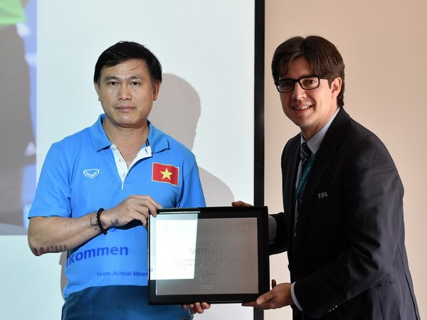 Trưởng đoàn Trần Anh Tú (trái) thay mặt tuyển Futsal Việt Nam nhận danh vị chứng nhận tham dự Futsal World Cup của FIFA. (Ảnh: VFF)