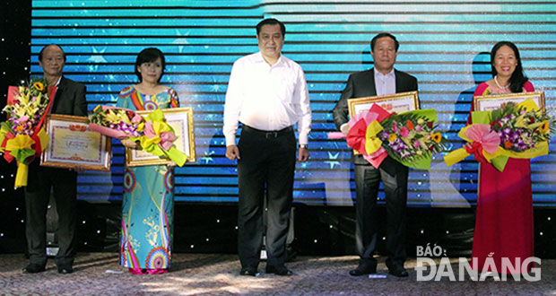Chủ tịch UBND thành phố Huỳnh Đức Thơ (giữa) chúc mừng các doanh nhân tiêu biểu khối doanh nghiệp địa phương năm 2016 do VCCI bình chọn. 				         Ảnh: KHÁNH HÒA