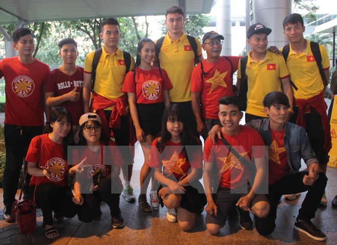 Các cầu thủ Đội tuyển bóng đá Việt Nam và người hâm mộ tại sân bay Tân Sơn Nhất. (Ảnh: TTXVN)