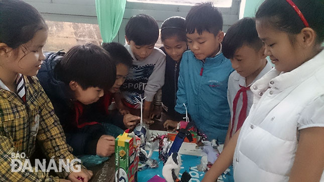 Học sinh Trường tiểu học Trần Quốc Toản thích thú với đồ dùng dạy học do các thầy cô tự làm từ phế phẩm.