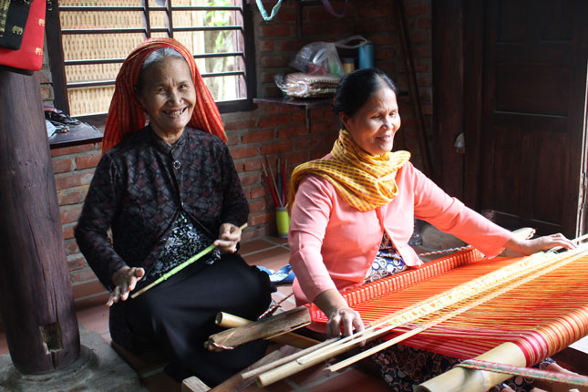 Nghệ nhân Đàng Thị Tình và em gái Đàng Thị Muốn bên khung dệt khăn thổ cẩm ở Làng lụa Hội An.