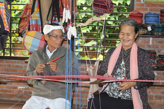 Vợ chồng nghệ nhân Đàng Thị Tình đã gặp và gắn bó với nhau suốt 50 năm nhờ nghề dệt thổ cẩm. Ảnh: H.L