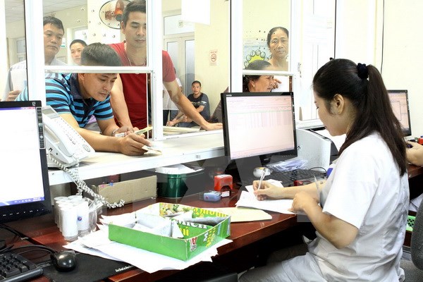 Nhân viên y tế làm các thủ tục khám chữa bệnh cho người dân. (Ảnh: TTXVN/Vietnam+)