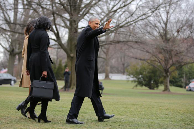Tổng thống Obama vẫy chào khi cùng Đệ nhất phu nhân Michelle và con gái Sasha rời Nhà Trắng để lên chuyến bay về Chicago. (Ảnh: Reuters)