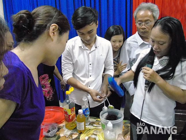 Chị Trịnh Thị Hồng, Giám đốc Công ty TNHH Minh Hồng hướng dẫn chị em tại phường Hòa Minh (quận Liên Chiểu) cách sản xuất sản phẩm tẩy rửa từ chế phẩm sinh học.
