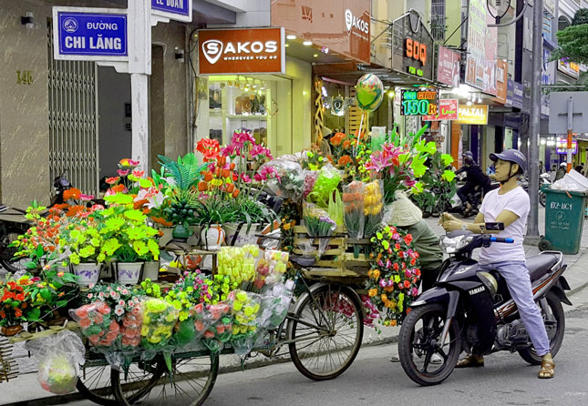Bên cạnh hoa tươi, người dân còn chọn mua các loại hoa giả để trang trí. 