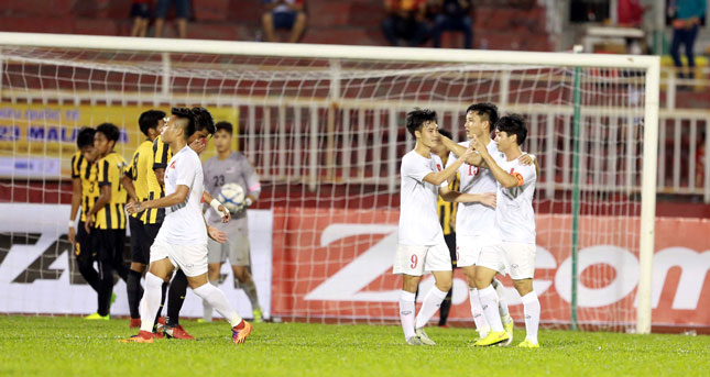 Niềm vui của các cầu thủ U-23 Việt Nam (áo trắng) sau chiến thắng trước U-23 Malaysia (áo sọc vàng - đen) ở trận giao hữu tối qua.                                           ảnh: NGUYÊN HUY