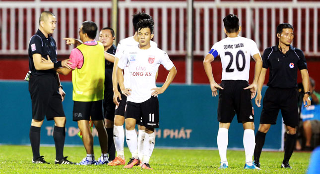 Sau sự cố đáng tiếc trên sân Thống Nhất, ông Ngô Quang Sang (áo vàng) bị cách chức HLV trưởng và cầu thủ Huỳnh Quang Thanh (số 20) bị tước băng đội trưởng ở CLB Bóng đá Long An.  		                                                                      Ảnh: NGUYÊN HUY