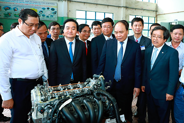 Thủ tướng Nguyễn Xuân Phúc (hàng trước, thứ hai, từ phải sang) thăm xưởng thực hành cơ khí của Trường Đại học Bách khoa (Đại học Đà Nẵng).  							      Ảnh: TTXVN