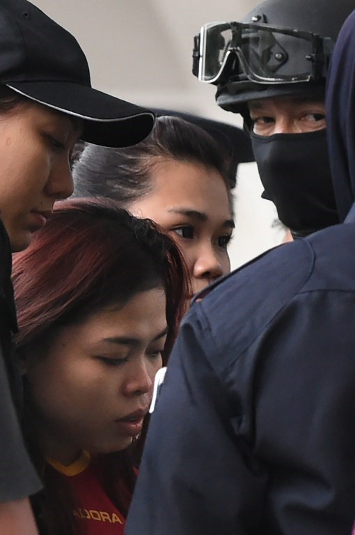 Nữ nghi phạm người Indonesia (áo đỏ) bị cảnh sát áp giải tới phiên tòa. (Ảnh: AFP)