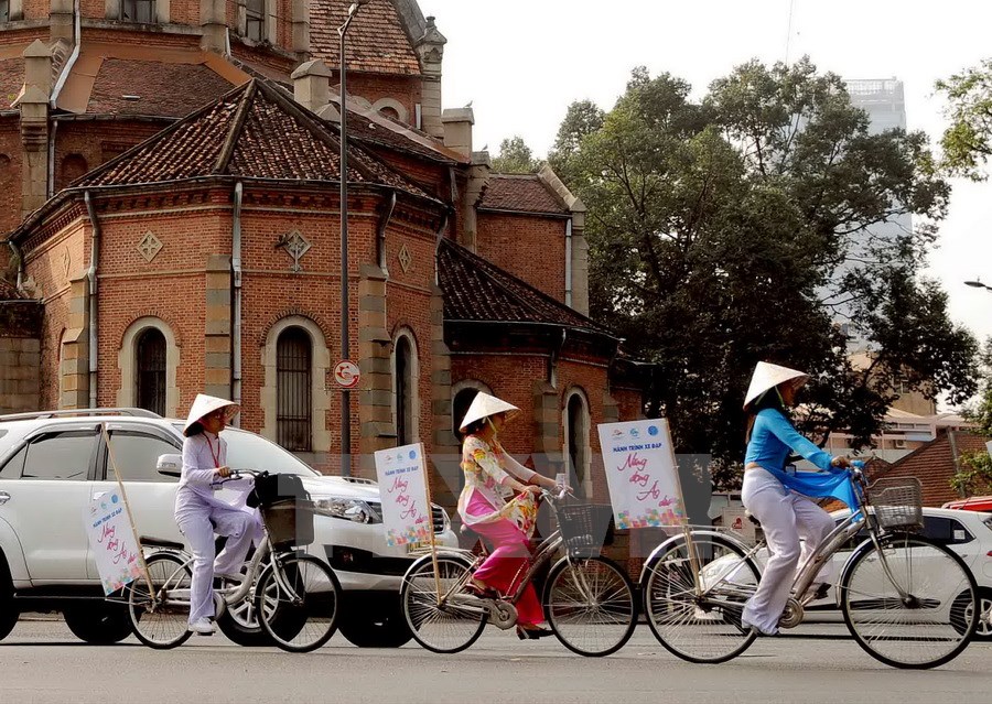 Hành trình xe đạp “Năng động áo dài” trên các tuyến đường trung tâm góp phần tuyên truyền “Chung tay vì ngành du lịch, mỗi người dân là một hướng dẫn viên du lịch.” (Ảnh: An Hiếu/TTXVN)