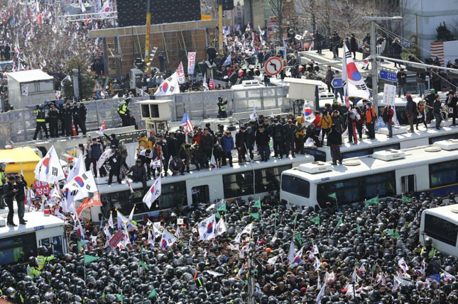 Trong cuộc tuần hành ngày 10-3, những người ủng hộ bà Park Geun-hye chặn các xe buýt của cảnh sát khi đoàn xe này tiến về phía Tòa án Hiến pháp.                                                                                                    Ảnh: AP