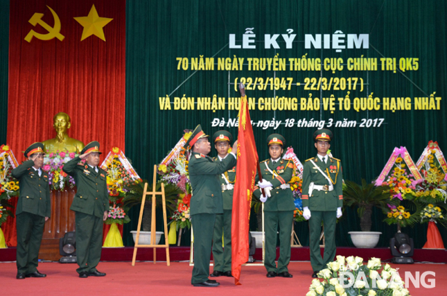 Thừa ủy quyền của Chủ tịch nước, Trung tướng Nguyễn Long Cáng, Tư lệnh Quân khu 5 gắn Huân chương Bảo vệ Tổ quốc hạng nhất lên Quân kỳ Quyết thắng của Cục Chính trị Quân khu 5.              Ảnh: NGỌC DIỆP