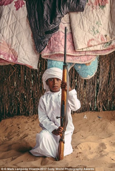Một cậu bé Bedouin ở Oman cầm khẩu súng của cha mình. Nhiếp ảnh gia Mark Languido Vicente giải thích: 