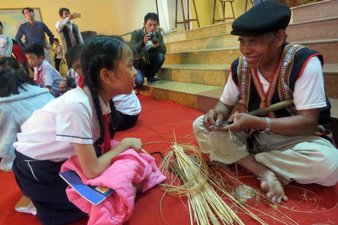 Ông Tơ ngôn Aping (người Cơ Tu đến từ huyện Nam Giang, tỉnh Quảng Nam) cười hạnh phúc khi mọi người xúm xít hỏi ông về nghề đan lát truyền thống của người Cơ Tu.