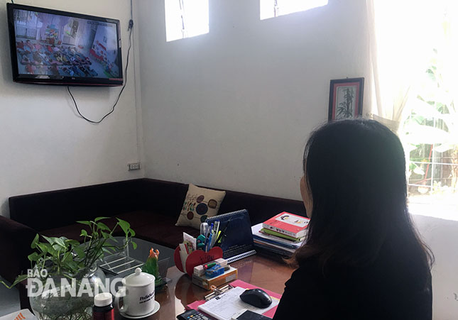 Cô Nguyễn Quốc Thư Trâm, Hiệu trưởng Trường mầm non Bình Minh quan sát hoạt động chăm sóc trẻ qua camera.