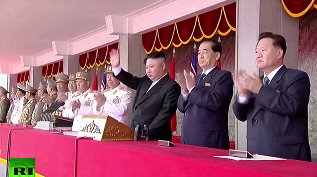 Ông Kim Jong-un vẫy tay khi các đoàn diễu binh đi qua khán đài